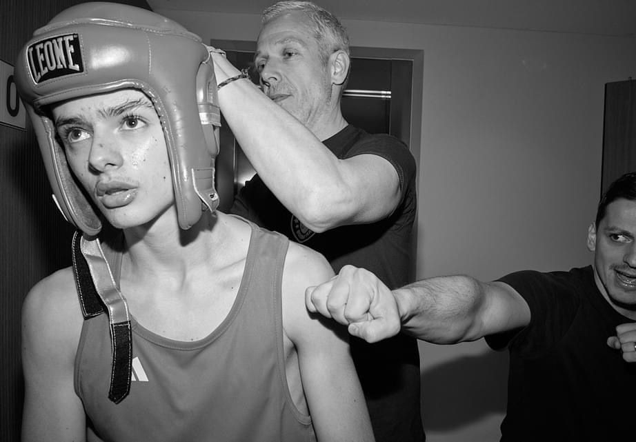 Un jeune boxeur se prépare avant son combat, aidé par ses coachs du club Boxe Waterloo, concentré et prêt à monter sur le ring.